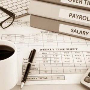Human resources documents: payroll, salary and employee  time sheets place on office table with cup of coffee and calculator, sepia tone